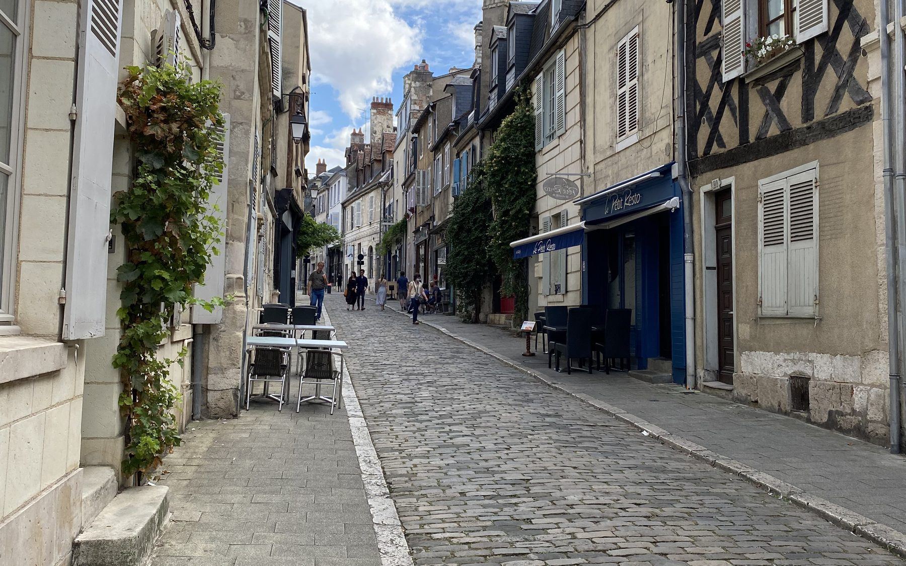 Rue pavée du vieux Bourges, maison à colombages et terrasse de café