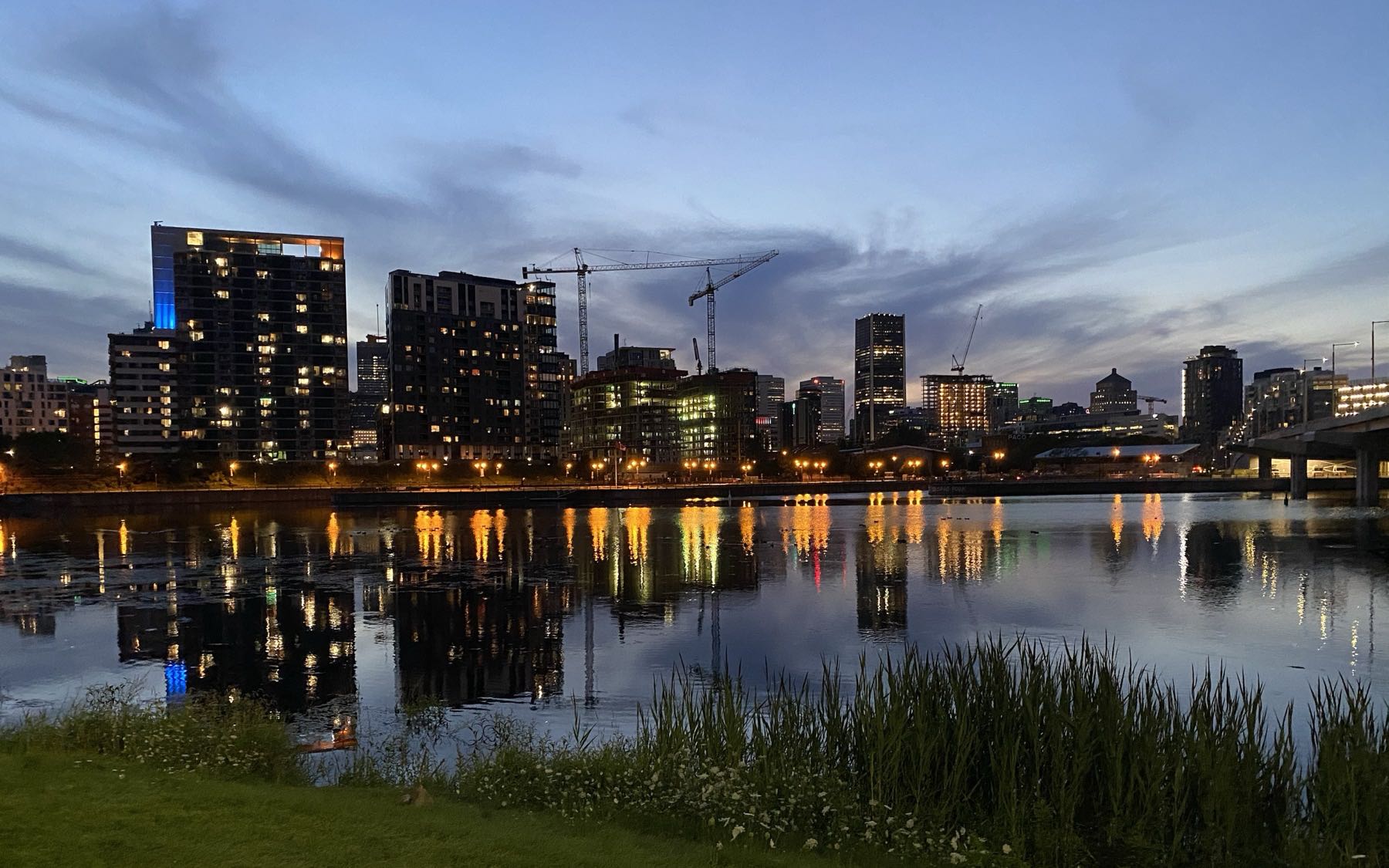 Montréal à la tombée de la nuit, immeubles et grues reflétés dans l'eau