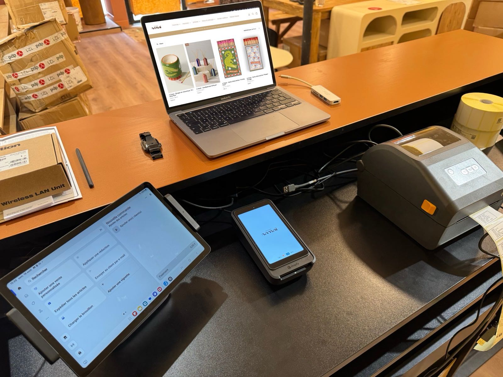 Comptoir de Maison Namaï : caisse sur tablette, terminal de paiement, imprimante d'étiquettes et portable affichant la boutique en ligne